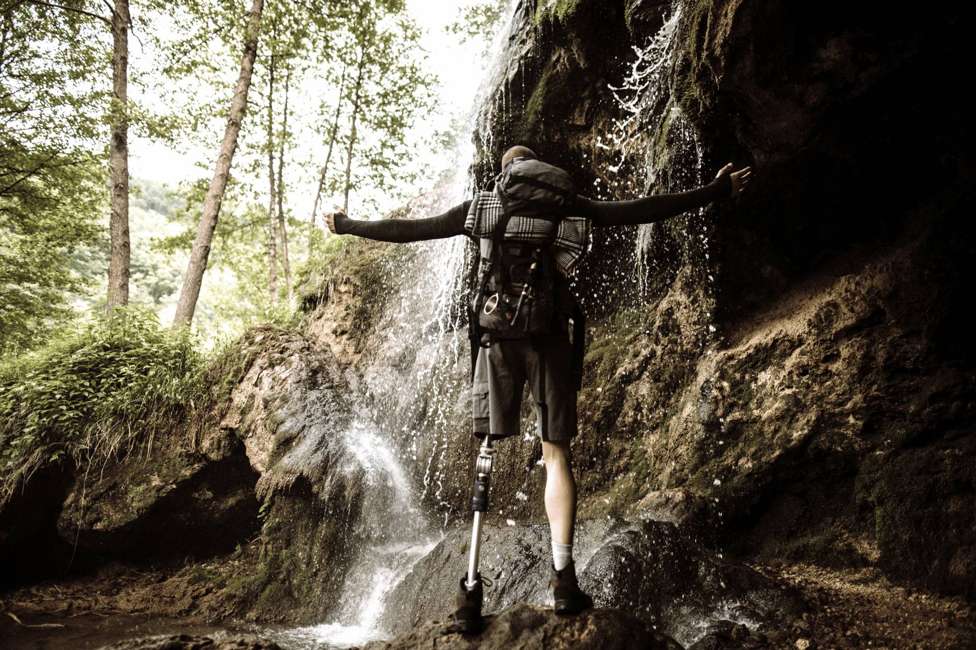 A amputee climbing with a waterfall