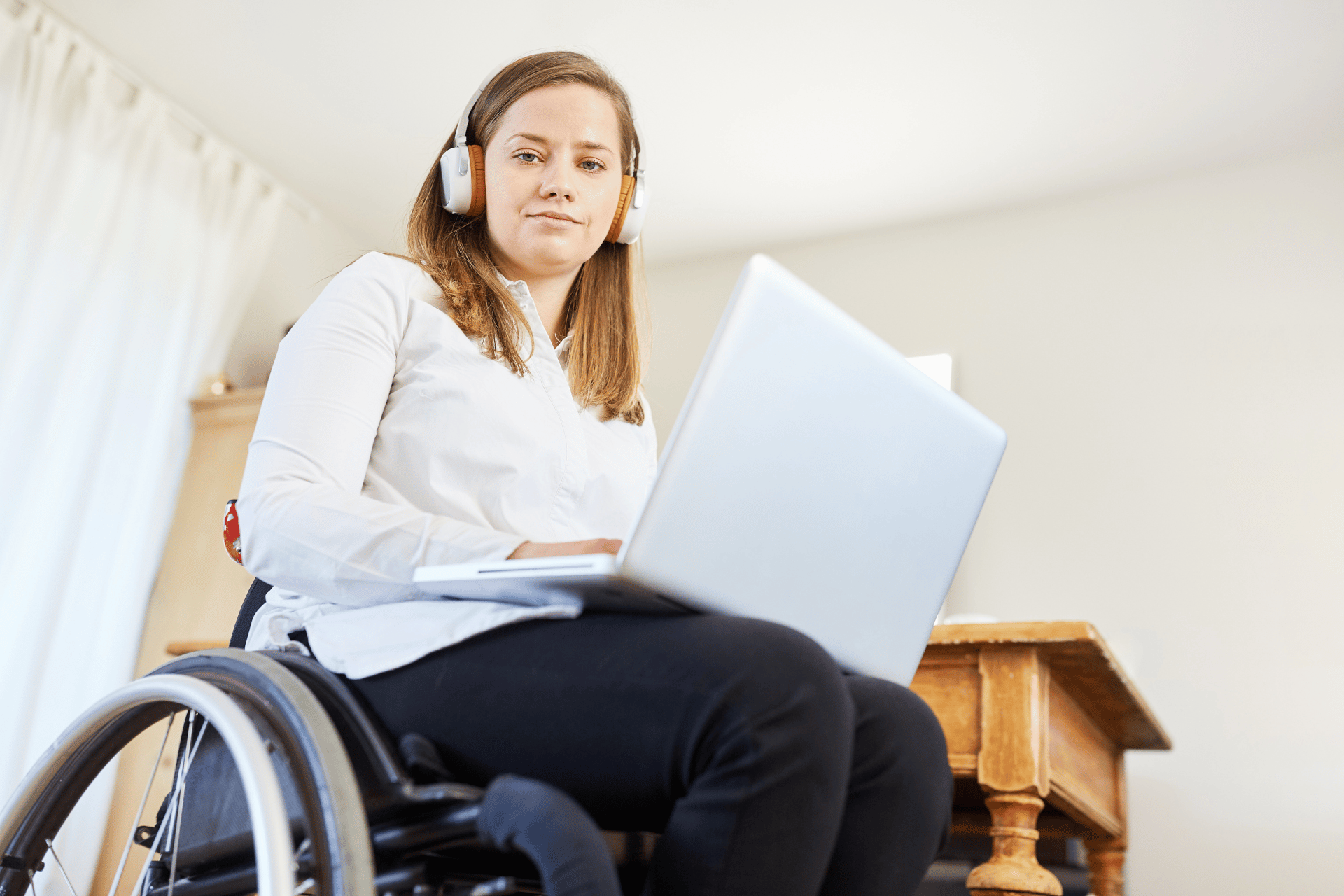 Women is a wheelchair using laptop