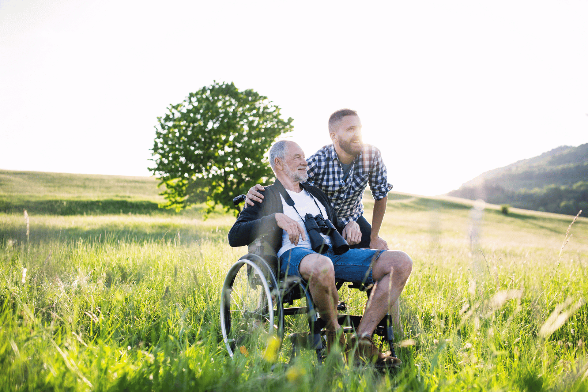 Man in a wheelchair in a field with looking glasses.