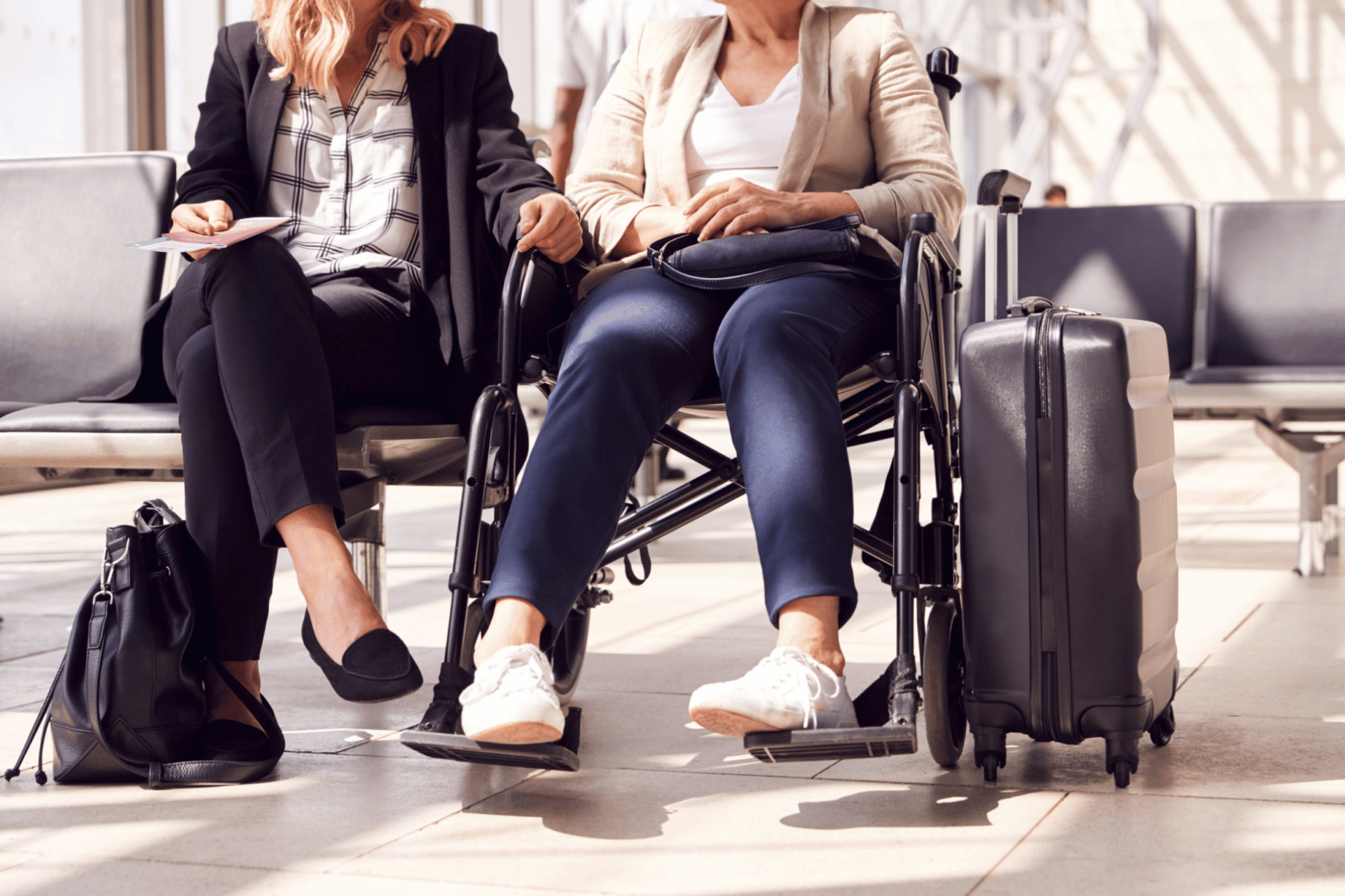 Females at an airport, one in a wheelchair