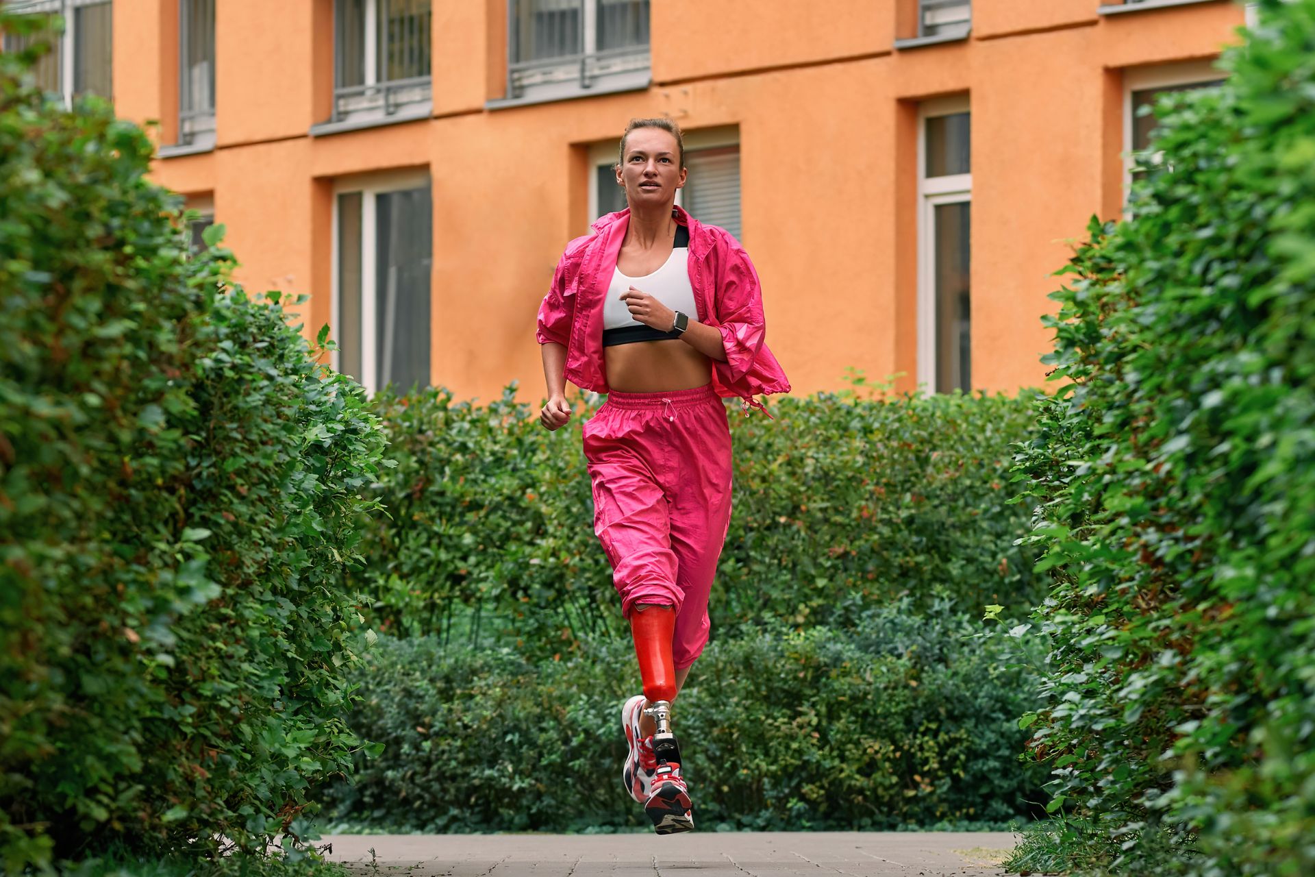 Disabled Sportswoman with Prosthetic Leg wearing a pink tracksuit