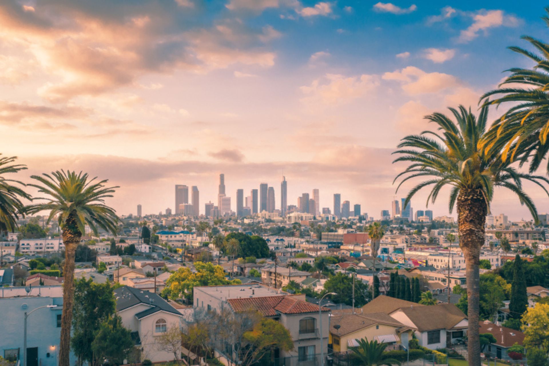Beautiful sunset of Los Angeles downtown skyline and palm trees ©Getty Images