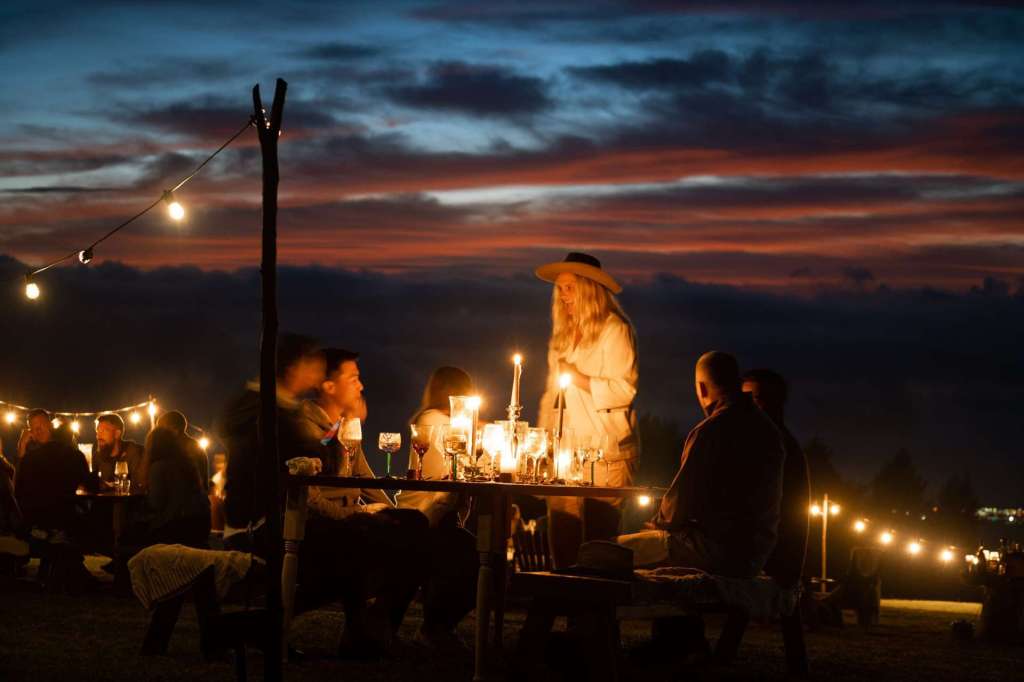 People enjoying an outdoor dinner with candles in Hawaii.