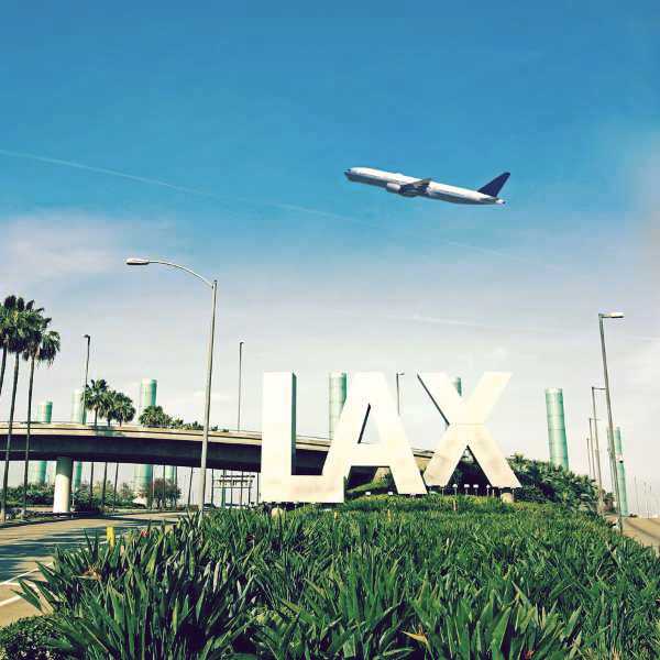Los Angeles Airport sign with airplane flying overhead