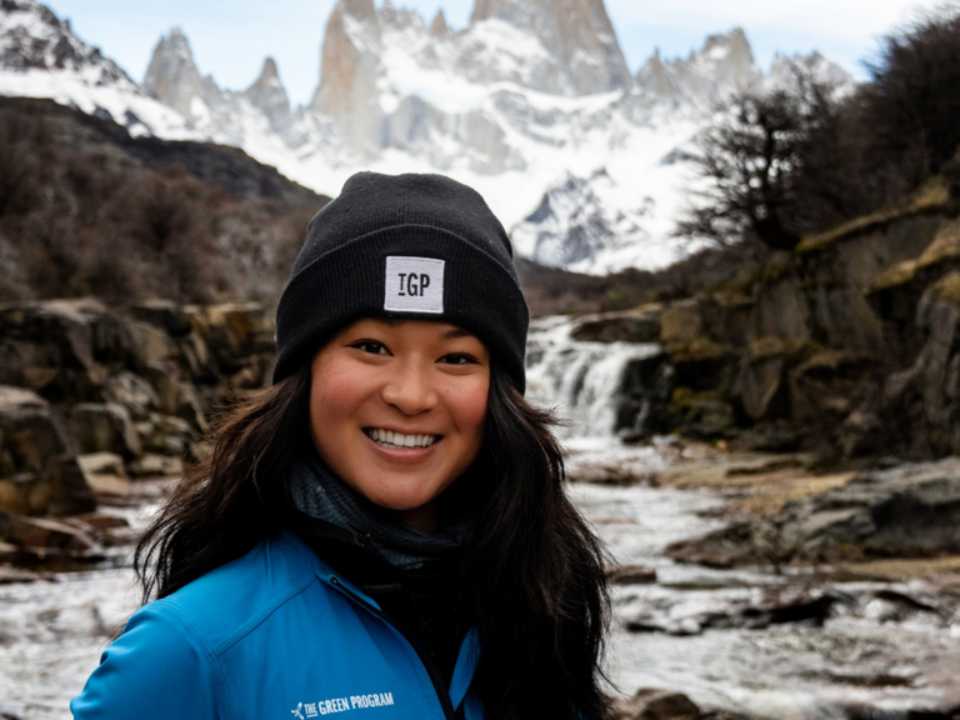 Melissa Lee smiling into the camera. Standing in front of a snowy mountain.