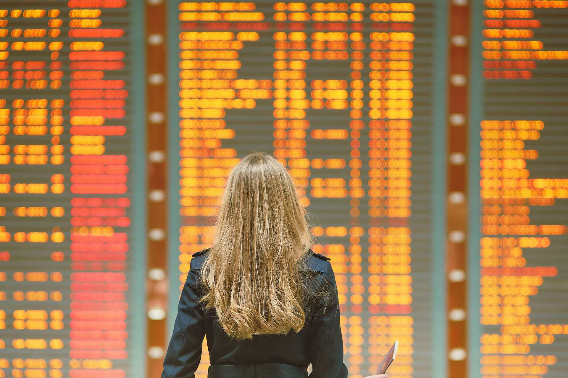 Young female traveler in international airport looking at departures board ©Getty Images