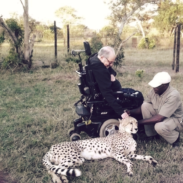 A man in a wheelchair petting a leopard on an Access2africa safari